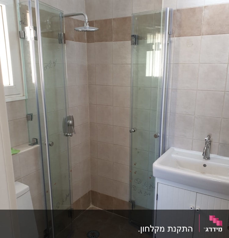 מקלחת עם דלתות זכוכית וראש מקלחת עגול